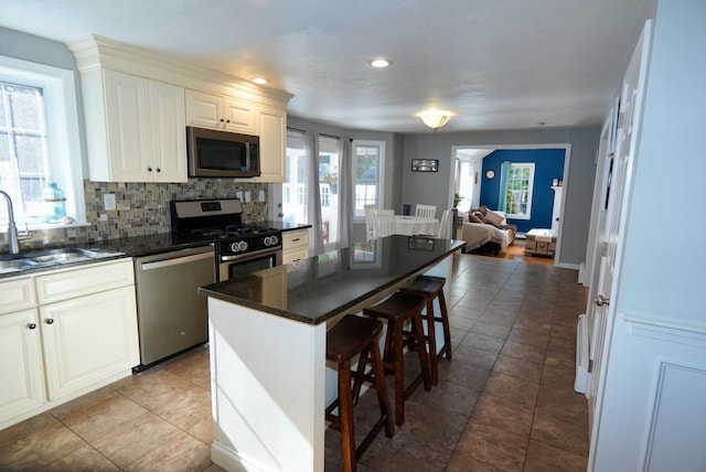 57 Camden Ln, Mashpee, MA 02649 - kitchen featuring appliances with stainless steel finishes, a sink, a kitchen bar, open floor plan, and a kitchen island