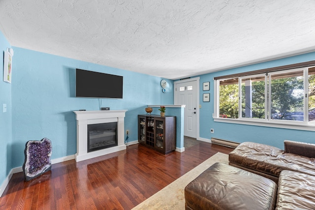 4 Bradford Acres Rd Unit F, Provincetown, MA 02657 - living area featuring a textured ceiling, a baseboard radiator, wood finished floors, and a glass covered fireplace