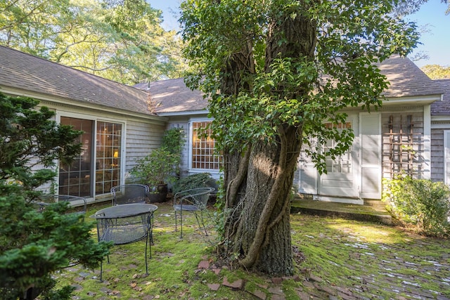rear view of house with a shingled roof