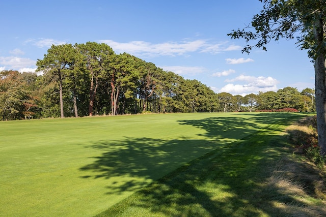 view of home's community with a lawn and view of golf course