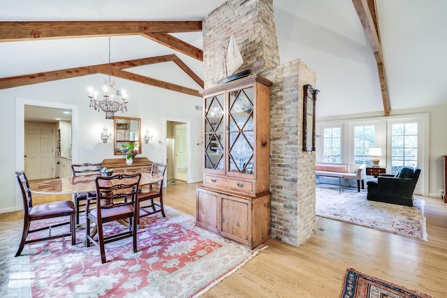 dining area with light wood-style flooring, beam ceiling, a chandelier, and high vaulted ceiling