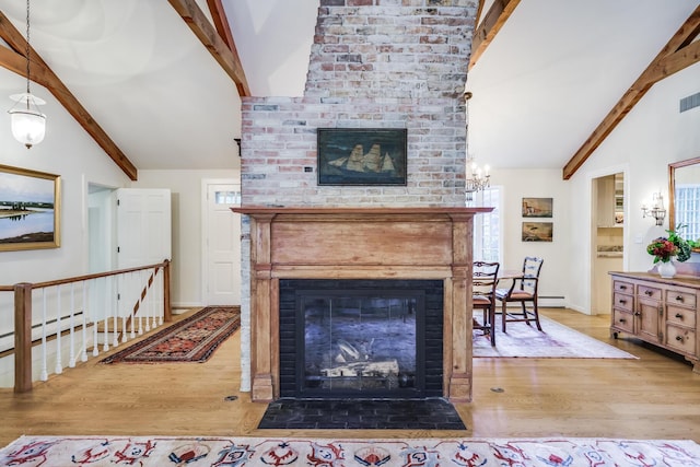 living room featuring a brick fireplace, wood finished floors, and baseboards