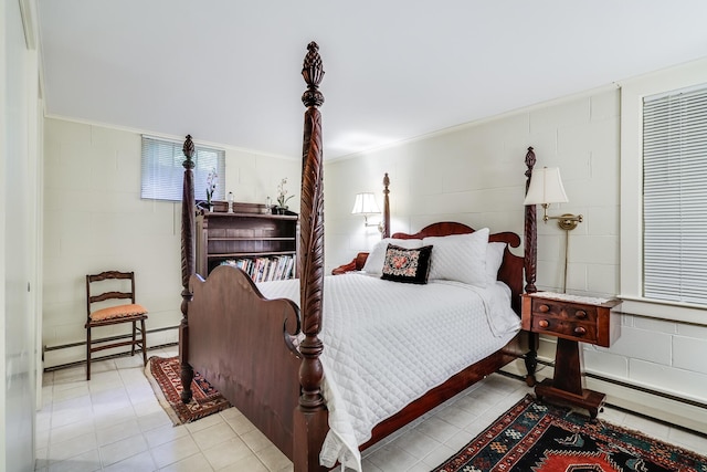 bedroom with concrete block wall and a baseboard radiator