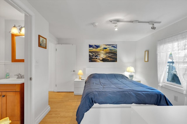 188 Captain Chase Rd, Dennis Port, MA 02639 - bedroom with light wood-style flooring, a sink, rail lighting, and ensuite bath