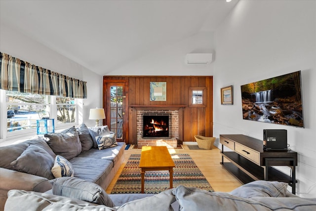 188 Captain Chase Rd, Dennis Port, MA 02639 - living room featuring high vaulted ceiling, a wall mounted air conditioner, light wood-style floors, and a fireplace