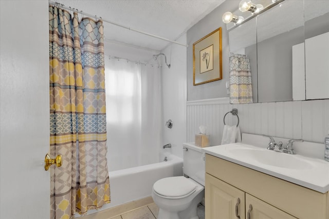 188 Captain Chase Rd, Dennis Port, MA 02639 - full bathroom featuring a textured ceiling, shower / bath combo with shower curtain, vanity, a wainscoted wall, and tile patterned flooring