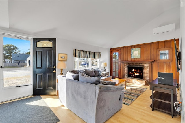 188 Captain Chase Rd, Dennis Port, MA 02639 - living area with light wood-style floors, a wall mounted air conditioner, a brick fireplace, and plenty of natural light