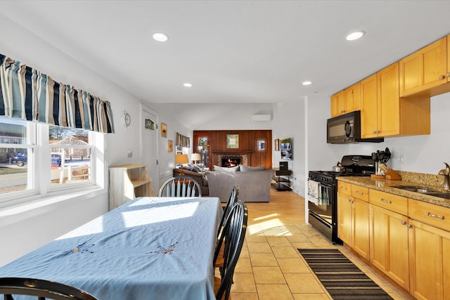 188 Captain Chase Rd, Dennis Port, MA 02639 - kitchen featuring light tile patterned floors, light brown cabinetry, black appliances, a sink, and a brick fireplace
