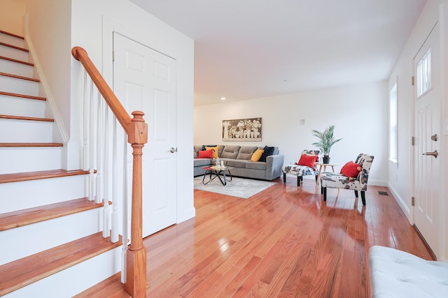 entryway with baseboards, stairway, visible vents, and light wood-style floors