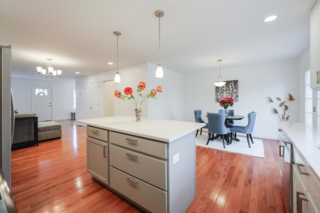 kitchen with light wood-style floors, stainless steel appliances, gray cabinets, and light countertops