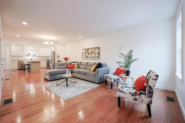 living area with light wood-style flooring, visible vents, a notable chandelier, and recessed lighting