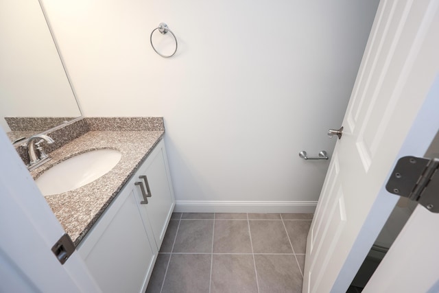 bathroom with vanity, baseboards, and tile patterned floors