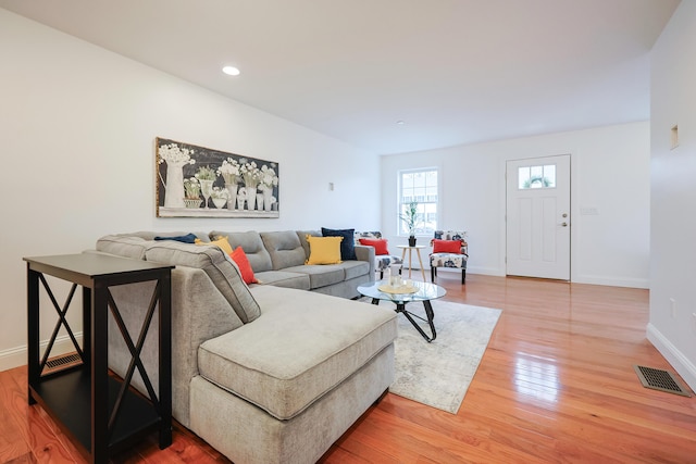 living room with recessed lighting, light wood-type flooring, visible vents, and baseboards