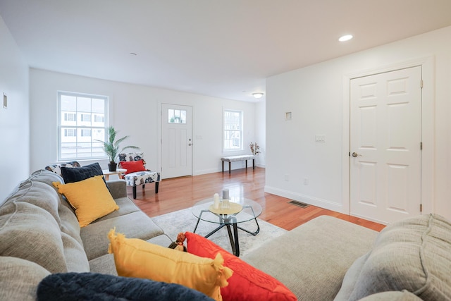 living area with light wood-style floors, baseboards, visible vents, and recessed lighting