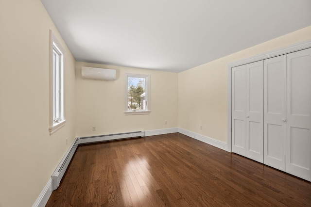 507 S Orleans Rd, Orleans, MA 02653 - unfurnished bedroom with a wall mounted AC, a baseboard radiator, dark wood finished floors, and baseboards