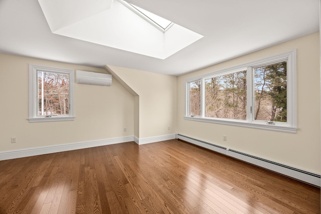507 S Orleans Rd, Orleans, MA 02653 - bonus room featuring a baseboard radiator, a wall mounted air conditioner, a skylight, wood finished floors, and baseboards