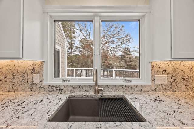 507 S Orleans Rd, Orleans, MA 02653 - kitchen view of a sink, decorative backsplash, light stone counters, and white cabinets