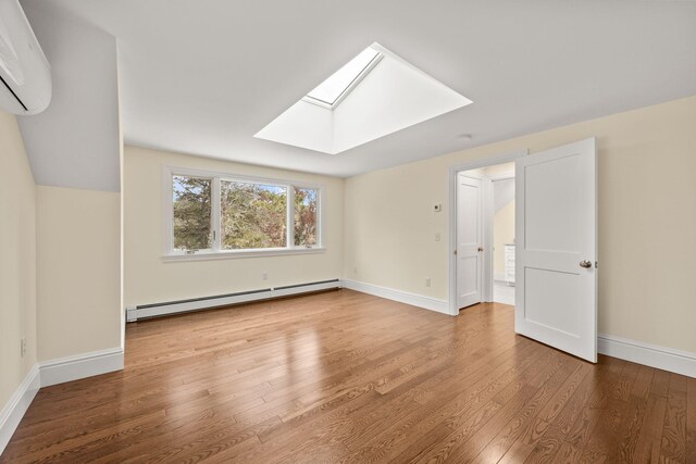 507 S Orleans Rd, Orleans, MA 02653 - additional living space with baseboard heating, a skylight, a wall mounted AC, wood finished floors, and baseboards