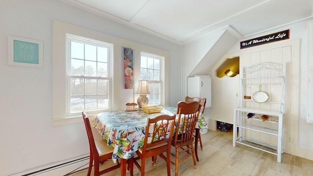 dining space with light wood-type flooring and baseboard heating