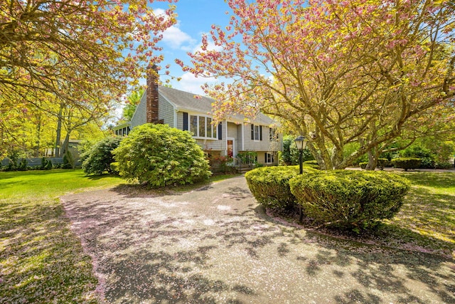 view of front facade with a front yard and a chimney