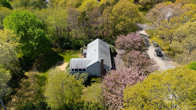 aerial view of property and surrounding area featuring a heavily wooded area