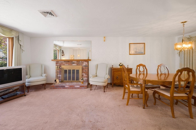 carpeted dining area with a chandelier and a fireplace