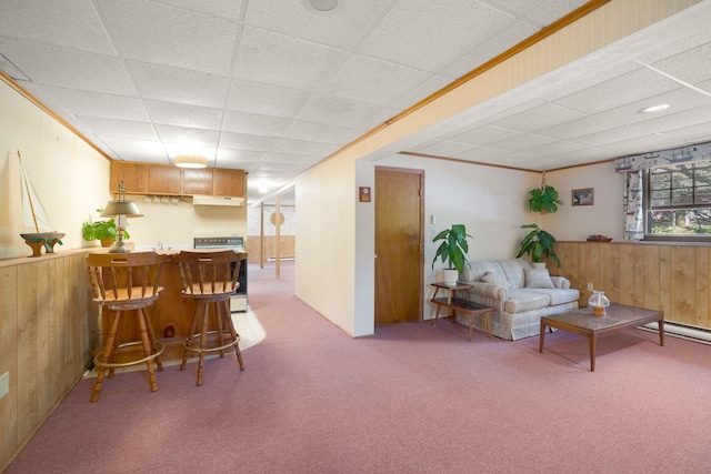 living area featuring light colored carpet, a dry bar, a paneled ceiling, and wood walls