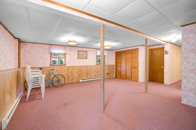 basement with baseboard heating, a drop ceiling, wainscoting, carpet floors, and wallpapered walls