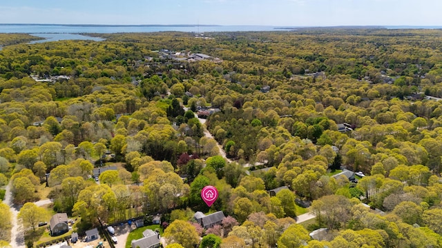 drone / aerial view of a heavily wooded area and a large body of water