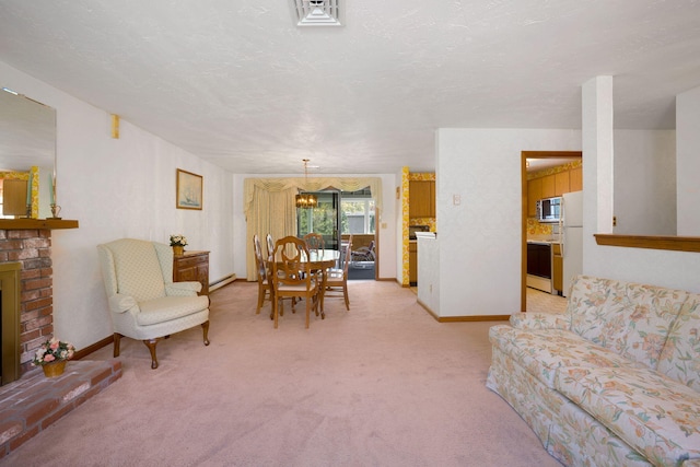 living area featuring a chandelier, light carpet, a fireplace, a baseboard radiator, and baseboards