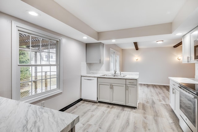 kitchen featuring white dishwasher, a sink, recessed lighting, stainless steel electric range, and light wood-style flooring