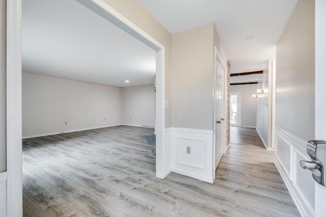 hall featuring wood finished floors and wainscoting