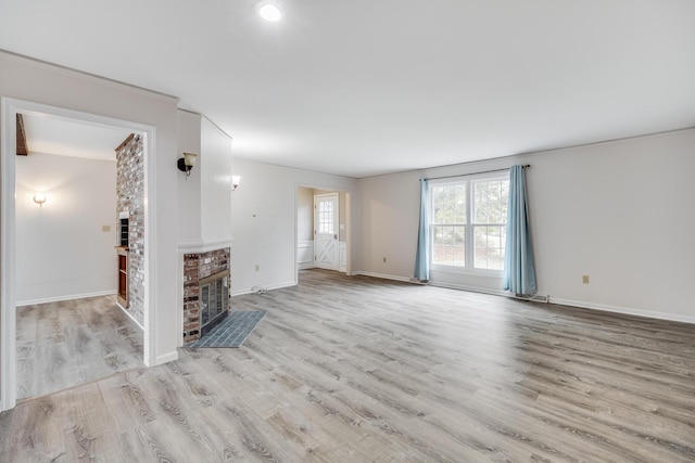 unfurnished living room featuring baseboards, wood finished floors, and a fireplace