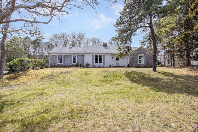 single story home featuring a chimney and a front lawn