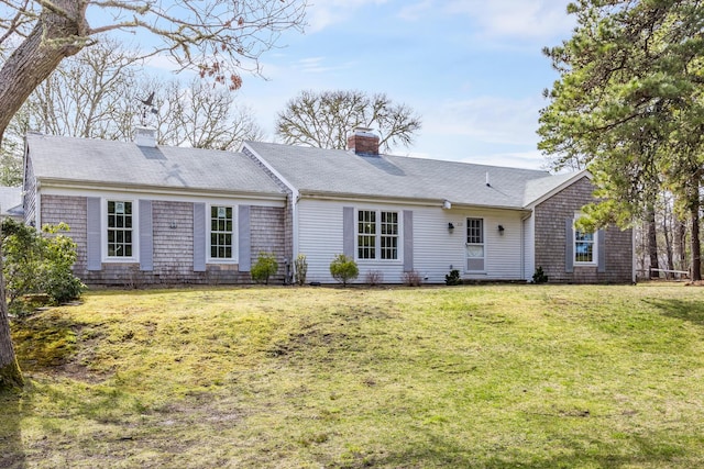 view of front of house featuring a chimney and a front yard