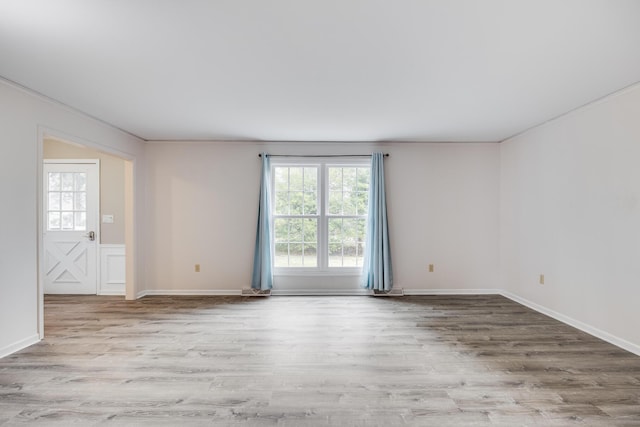 empty room featuring crown molding and wood finished floors