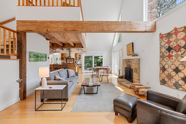 130 Daniels Dr, Wellfleet, MA 02667 - living area with wood finished floors, a fireplace, stairs, beamed ceiling, and a high ceiling