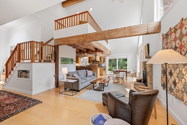 130 Daniels Dr, Wellfleet, MA 02667 - living area with high vaulted ceiling, stairway, wood finished floors, beamed ceiling, and a fireplace with raised hearth