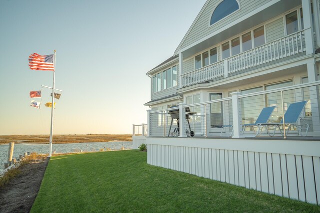 yard at dusk featuring a water view