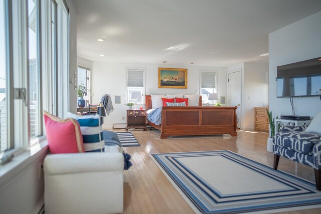 bedroom featuring baseboard heating, recessed lighting, and wood finished floors