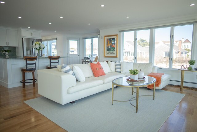 living room with crown molding, recessed lighting, wood finished floors, and a baseboard radiator