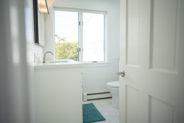 bathroom with vanity, a baseboard radiator, a healthy amount of sunlight, and toilet