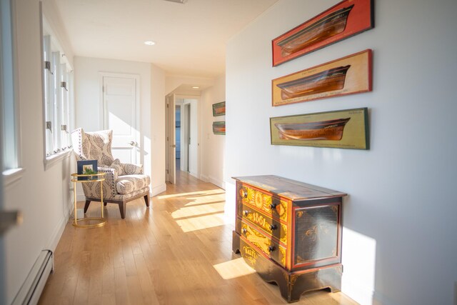 hallway featuring recessed lighting, baseboards, a baseboard heating unit, and wood finished floors