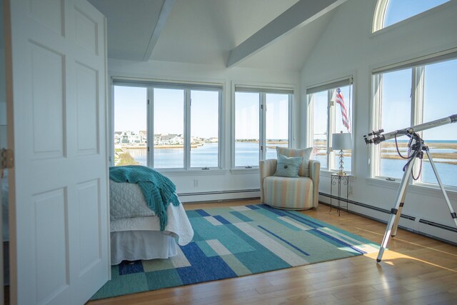 interior space featuring lofted ceiling with beams, a water view, multiple windows, and baseboard heating