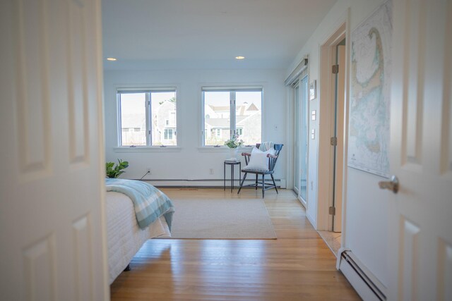 bedroom featuring light wood-style floors, a baseboard radiator, and recessed lighting