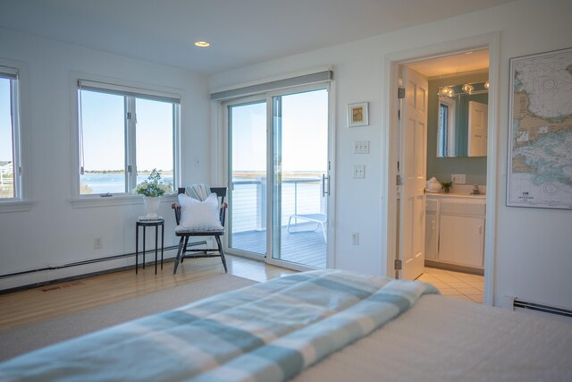 bedroom featuring access to outside, a baseboard radiator, recessed lighting, and multiple windows