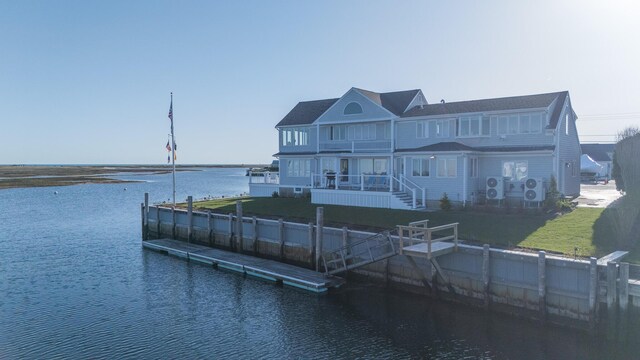 back of property featuring a water view, a yard, and a balcony