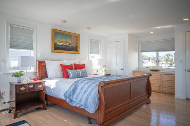 bedroom featuring light wood-style floors, a baseboard radiator, and recessed lighting
