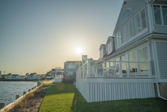 exterior space featuring a lawn and a water view