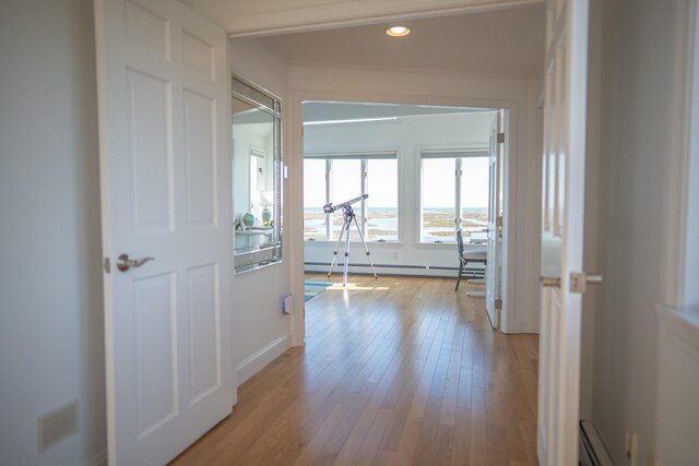 corridor with visible vents, baseboards, recessed lighting, a baseboard heating unit, and light wood finished floors